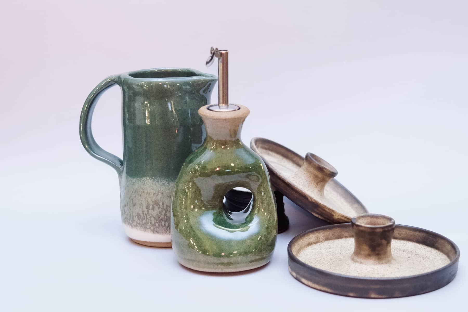 Forest green artisan oil cruet with metal spout, detailed view.