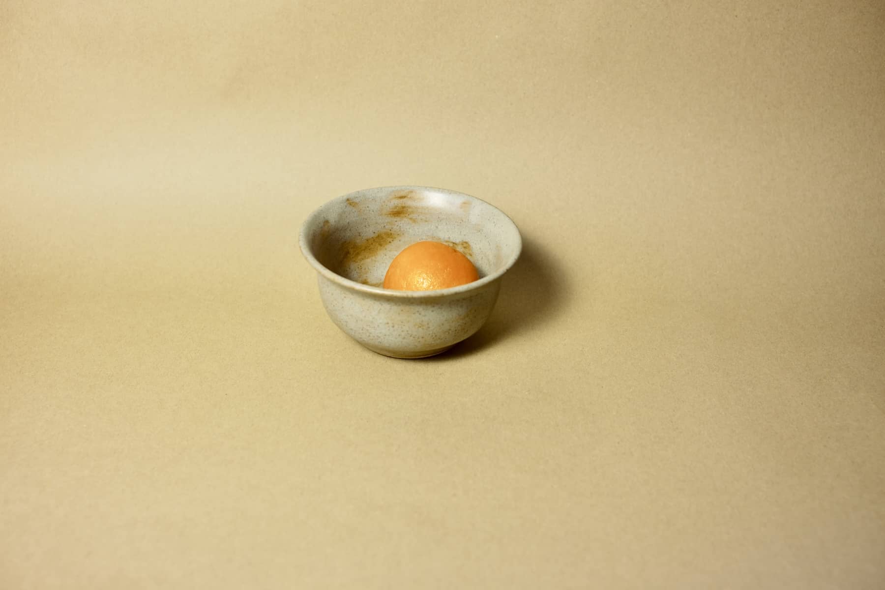 Sand-tone breakfast bowl with natural iron spotting, interior view.