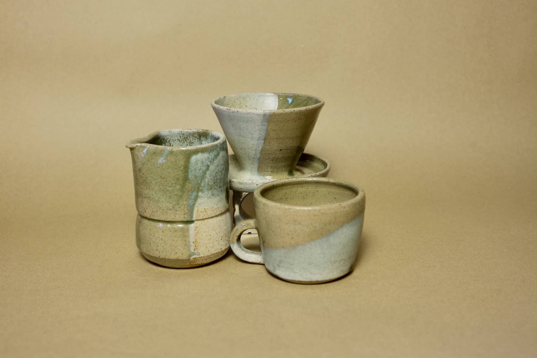Hand-thrown ceramic mug in sage green and cream split-glaze finish.