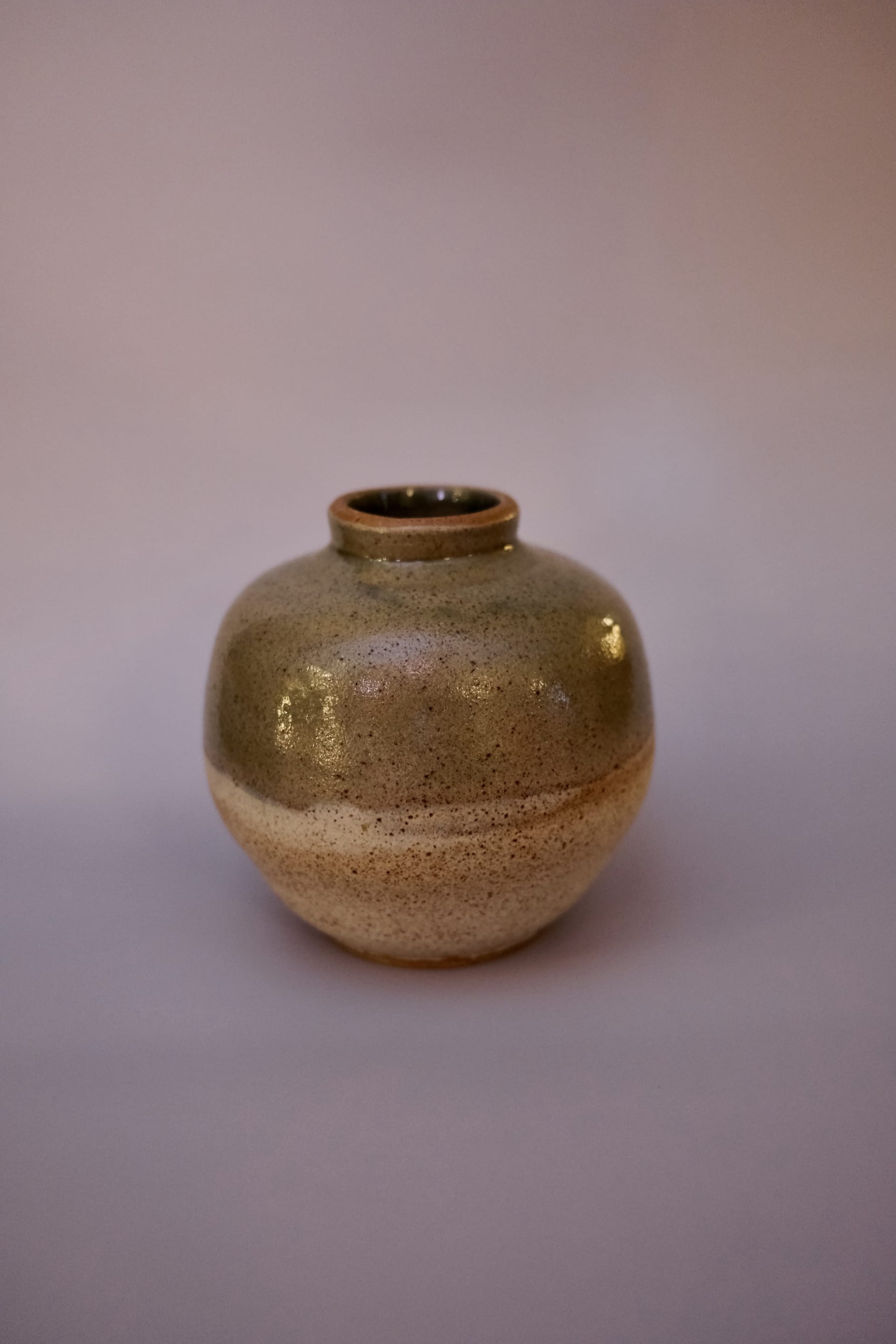 Speckled moon vase showing spherical form with heavy iron speckling.