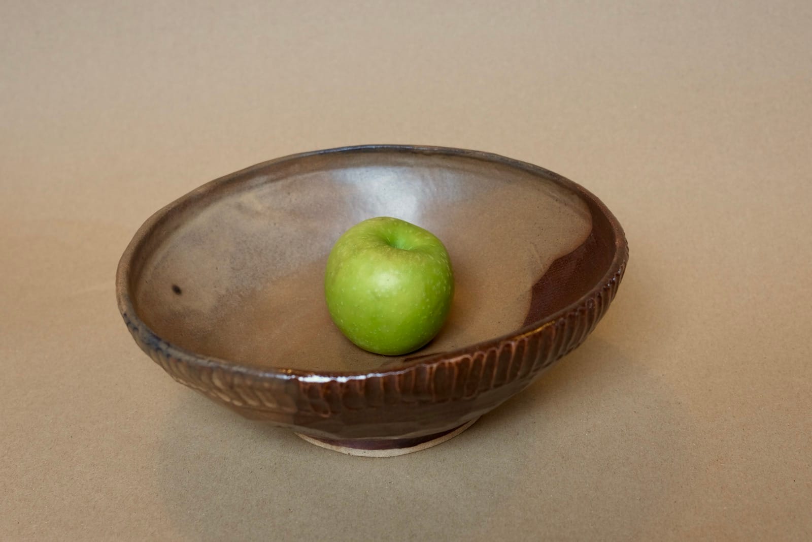 Large serving bowl with hand-carved geometric pattern and rich brown interior.